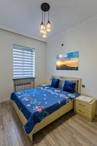 um quarto com uma cama com um edredão azul em Apartment close to İzmir Park em Baku