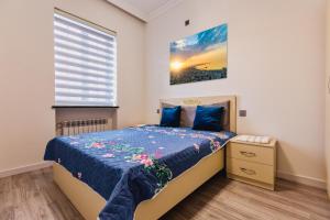 um pequeno quarto com uma cama e uma janela em Apartment close to İzmir Park em Baku