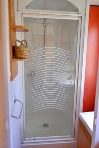 a shower with a glass door in a bathroom at Le jardin de Domi in Ventiseri