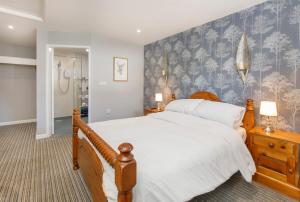 a bedroom with a large bed and a blue wall at The Angel Inn Pub-Dine & Stay Misson in Misson