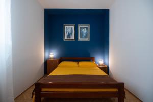 a bedroom with a bed with a blue wall at Clementa Apartment in Zadar