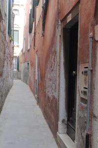 an alley with an open door to a building at B&B Cà Del Modena in Venice