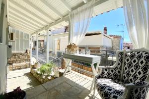 a balcony with a couch and a table on a roof at Mageiras Boutique Hotel in Afitos