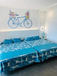 1 dormitorio con 1 cama con una bicicleta en la pared en Hotel Sorra Daurada Splash, en Malgrat de Mar