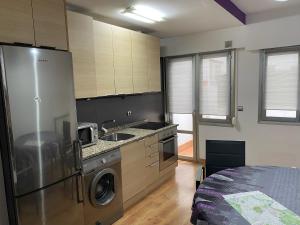 a kitchen with a stainless steel refrigerator and a sink at Apartamento Berria in Pamplona