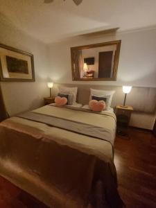 a bedroom with a large bed with two pink pillows at Vila De Sol in Sesimbra
