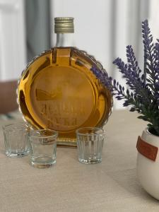 una botella de whisky y vasos en una mesa en Dedina kuća en Gornji Milanovac