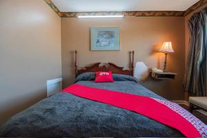 Un dormitorio con una cama grande con un arco rojo. en OYO Hotel Calhoun, GA I-75 en Calhoun
