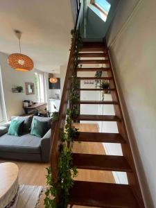 a wooden staircase with plants on it in a living room at Havre de tranquillité entre Paris et Versailles in Chaville