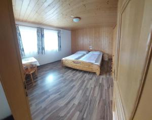 um quarto com uma cama e piso em madeira em Appartements Bodenland em Wildschönau