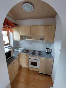 une cuisine avec une arche au milieu dans l'établissement Appartements Bodenland, à Wildschönau