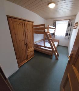 Cette petite chambre comprend des lits superposés et un placard. dans l'établissement Appartements Bodenland, à Wildschönau