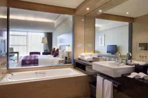 a bathroom with a tub and a large mirror at Crowne Plaza Tianjin Binhai, an IHG Hotel in Tianjin