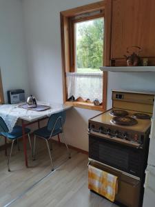 a kitchen with a stove and a table and a window at Vigra vintage in Vigra