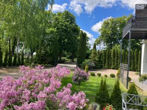 ogród z różowymi kwiatami i drzewami w obiekcie Apartamenty Arkadia przy Amfiteatrze w mieście Mrągowo