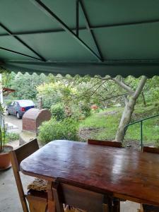 克利默內甚蒂的住宿－Casuta Maria Alexandra，一张木桌,坐在绿色的屋顶下