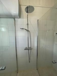 a shower with a glass door in a bathroom at Lyckan - Minihus i lantlig miljö in Ulricehamn