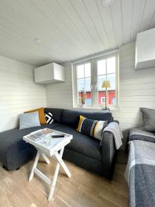 uma sala de estar com um sofá e uma mesa em Lyckan - Minihus i lantlig miljö em Ulricehamn