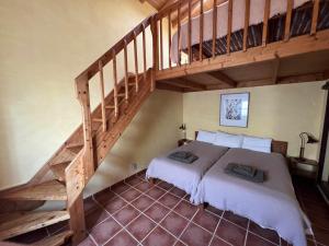 a bedroom with a bed and a wooden staircase at Casa Presente Guesthouse in Carrapateira