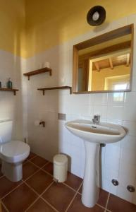 a bathroom with a sink and a toilet at Casa Presente Guesthouse in Carrapateira