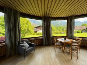 - une salle à manger avec une table, des chaises et de grandes fenêtres dans l'établissement Aparthotel Hochfeld, à Schönau am Königssee