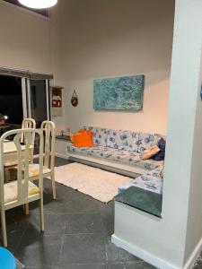 ein Wohnzimmer mit einem Sofa, einem Tisch und Stühlen in der Unterkunft Casa de praia em Riviera no Módulo 21 in Bertioga