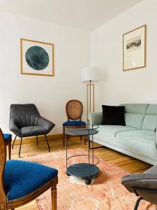 ein Wohnzimmer mit einem Sofa und Stühlen in der Unterkunft NEOUVIELLE CAUTERETS in Cauterets