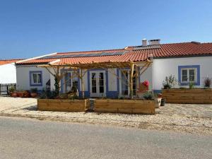 a small white house with a red roof at Casa Presente Guesthouse in Carrapateira