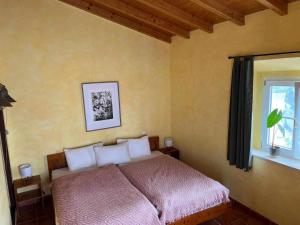 a bedroom with a bed and a window at Casa Presente Guesthouse in Carrapateira