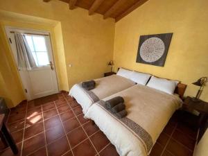 a bedroom with a large bed and a window at Casa Presente Guesthouse in Carrapateira