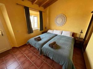 a bedroom with a large bed with towels on it at Casa Presente Guesthouse in Carrapateira