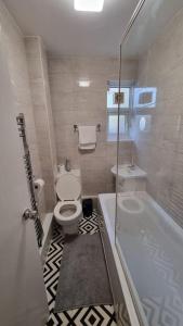 a bathroom with a toilet and a tub and a sink at 2 Bedroom apartment in Kennington London in London
