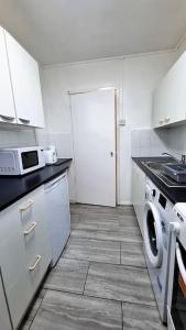a kitchen with a washing machine and a washer at 2 Bedroom apartment in Kennington London in London