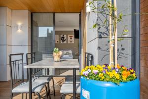 a dining room with a table and flowers at Haifa PORT Patio Apartment 2 BDRM in Haifa
