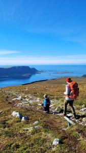 a woman and a child walking up a hill at Haramsøy One Night Glamping- Island Life North- overnight stay in a tent set up in nature- Perfect to get to know Norwegian Friluftsliv- Enjoy a little glamorous adventure in Haram