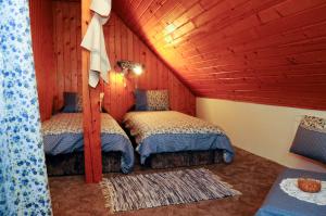 a bedroom with two beds in a attic at Kishalász Vendégház-Lovas in Lovas