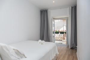 um quarto branco com uma cama branca e uma janela em Arrabida House em Setúbal