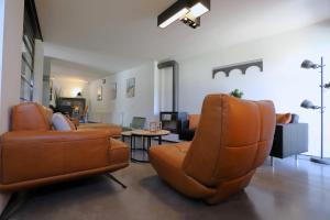 Yvoir的住宿－Aux Berges du Bocq，客厅配有两把椅子和一张沙发