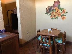 a table and chairs in a kitchen with a painting on the wall at HOTEL QUINTA SANTA CECILIA in Cuatroci&eacute;negas de Carranza