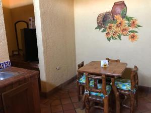 uma mesa e cadeiras numa cozinha com um quadro na parede em HOTEL QUINTA SANTA CECILIA em Cuatrociénegas de Carranza