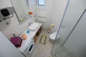 a bathroom with a toilet and a sink and a shower at Clementa Apartment in Zadar