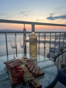 a glass table with a bottle of wine and food on it at Dolce vita Apartment in Senj +49 photos