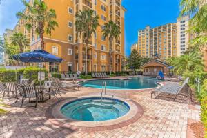 a patio with chairs and a pool in front of a building at Pirate Ship Resort Condo in Orlando