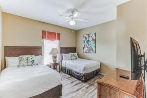 um quarto com 2 camas e uma televisão de ecrã plano em Pirate Ship Resort Condo em Orlando