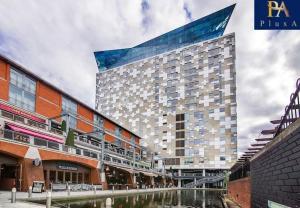a large building with a canal in front of it at Pluxa Azure Cubic - Azure Cityview, Corporate Stays Welcome in Birmingham