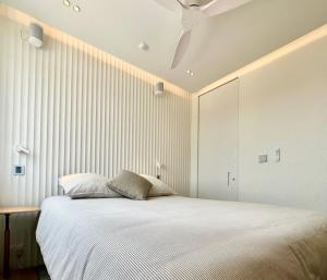a bedroom with a large white bed with a ceiling at Vue de l'Océan à la forêt, la plage à vos pieds in Soorts-Hossegor