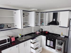 a kitchen with white cabinets and a black counter top at Stone House Aparts 1 plus 1 mit Poolterrasse No 3 in Kalkan in Kalkan