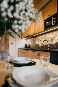 a kitchen with a table with dishes on it at Apartamenty Górajski Spa in Kościelisko