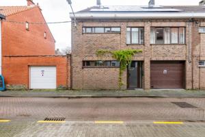 un bâtiment en briques avec deux portes de garage dans une rue dans l'établissement African heritage Tervuren, à Tervuren