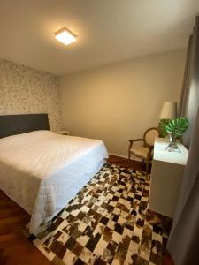 een slaapkamer met een bed en een geruite vloer bij Apto completo e com estacionamento em Curitiba in Curitiba